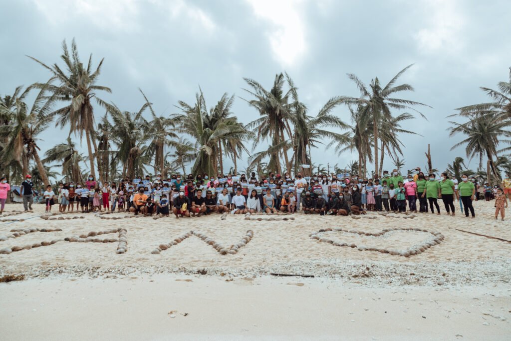 Halian community members and volunteers gathered on the beach during the Odette relief mission