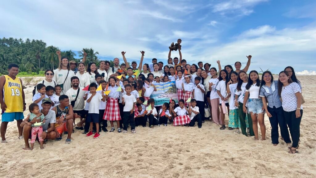Mam.on community members, students and volunteers gathered on the beach after the mission