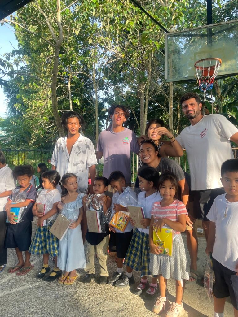 Young learners and volunteers posing with school kits
