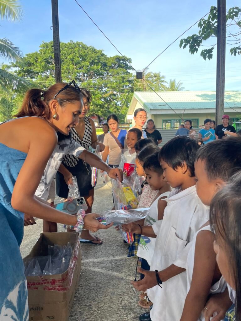 Volunteers handing school supplies to Katipunan learners