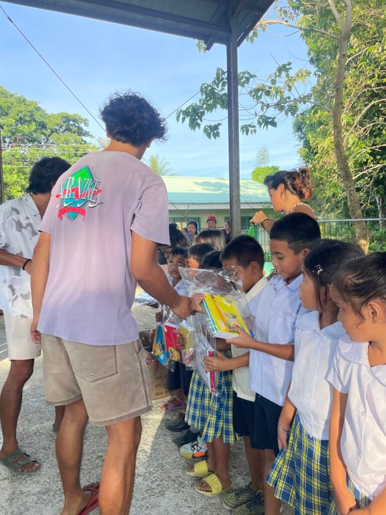 A volunteer distributing school packs to students