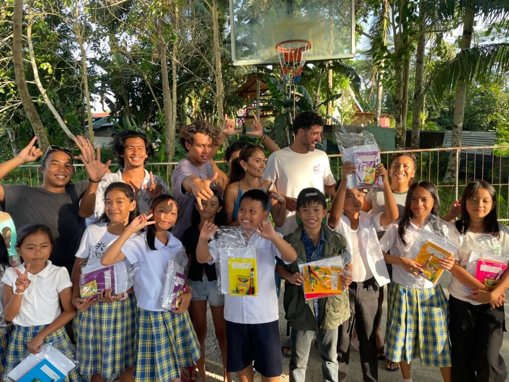 Students holding school packs with volunteers at Katipunan Elementary School