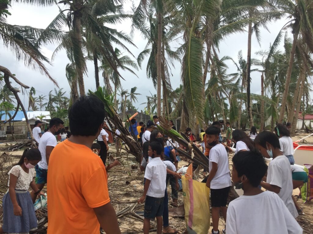 Community members and volunteers collecting litter during a beach cleanup in Halian