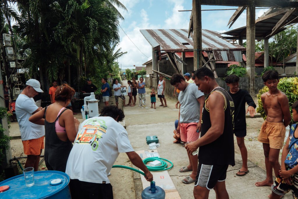 Community members gathering around the SkyHydrant setup in Monserrat, Dapa