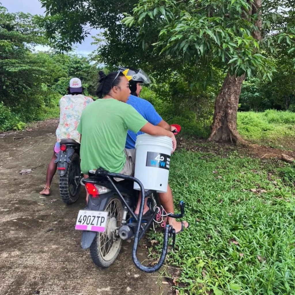 Transporting a Waves for Water filter bucket by motorcycle