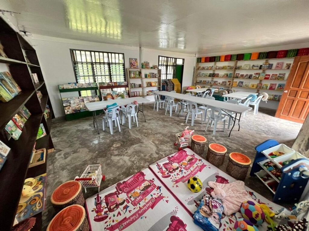 Interior of Halian Elementary School Library with bookshelves, tables and a children’s reading area