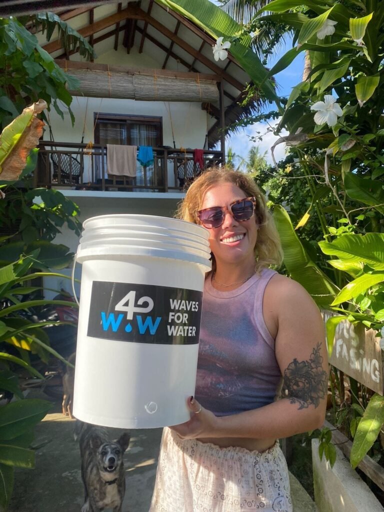 Volunteer holding a Waves for Water filter bucket