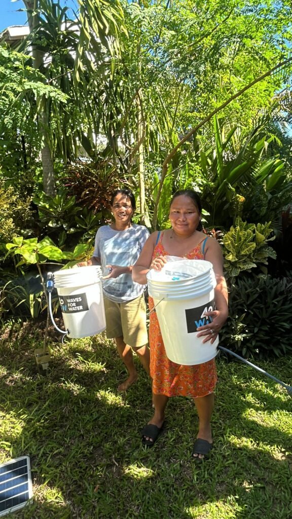 Community members holding Waves for Water filter buckets